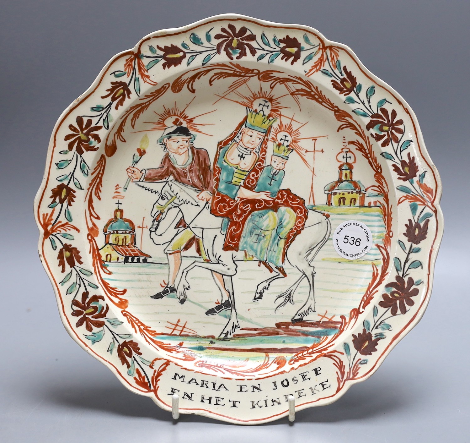 A Dutch decorated Leeds creamware plate, 'Joseph, Mary and the infant, Christ' (Flight into Egypt), circa 1780. 25cm diameter